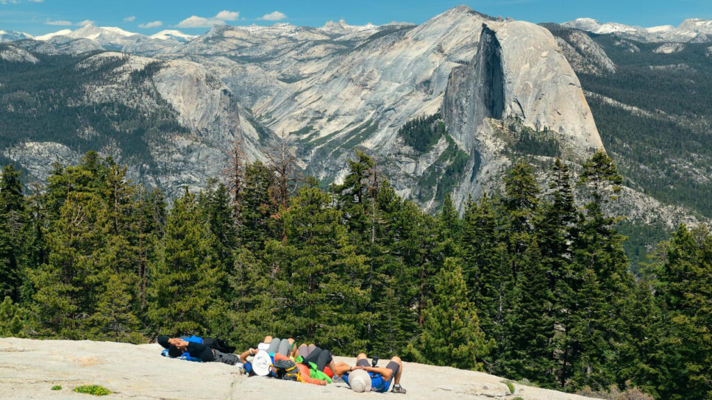 Hiker exploring forest trail with mountain views in Yosemite