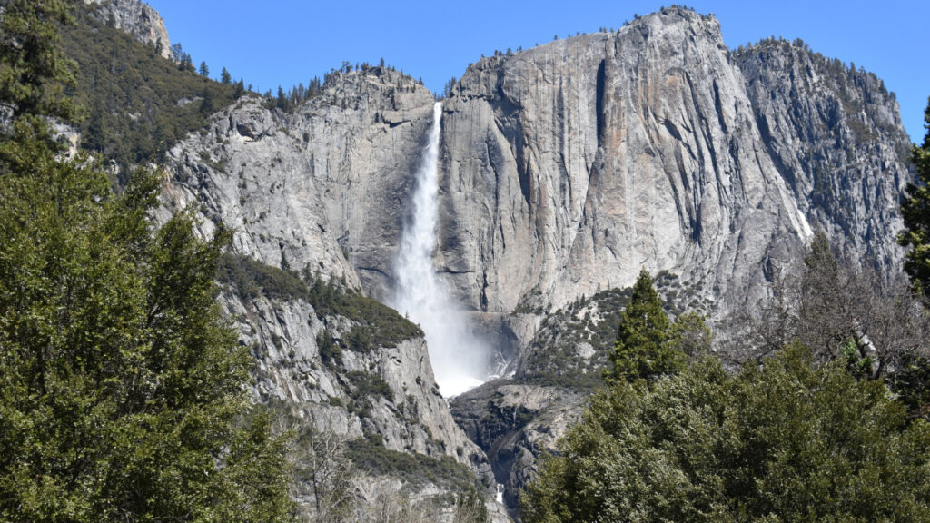 Scenic waterfall and granite cliffs during a Yosemite hiking trail