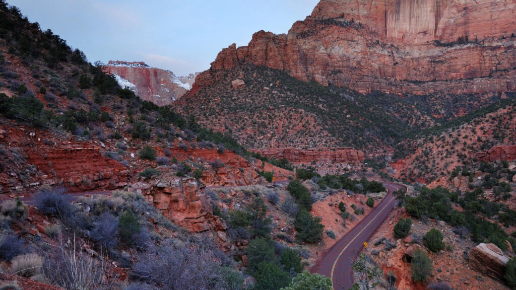 Red sandstone cliffs towering over Zion canyon landscape