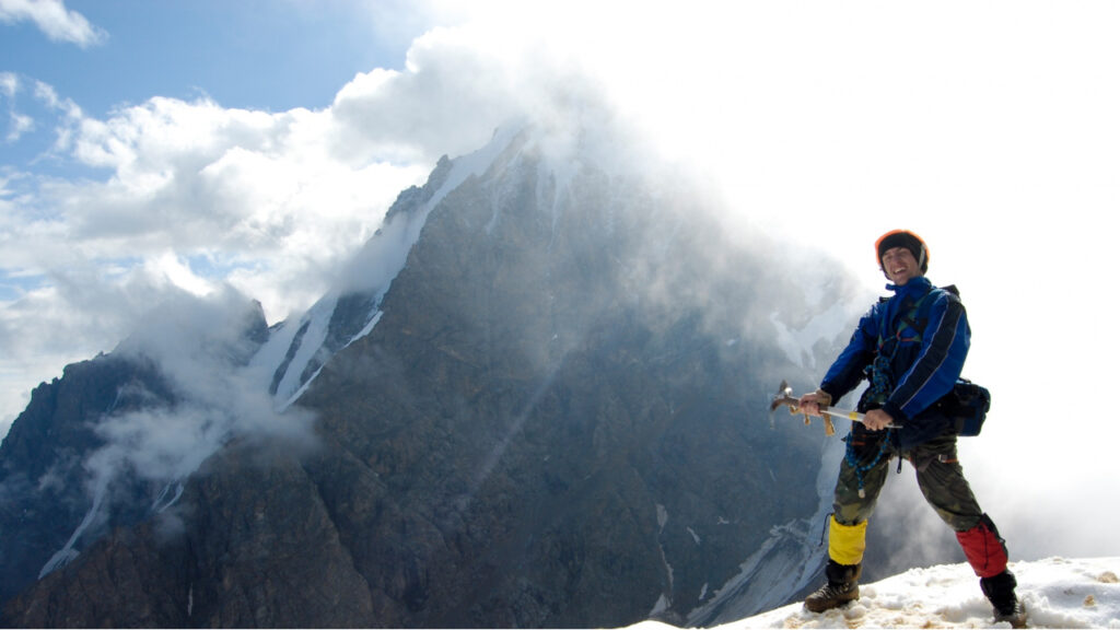 Trekker wearing a backpack and trekking boots walking on a mountain trail