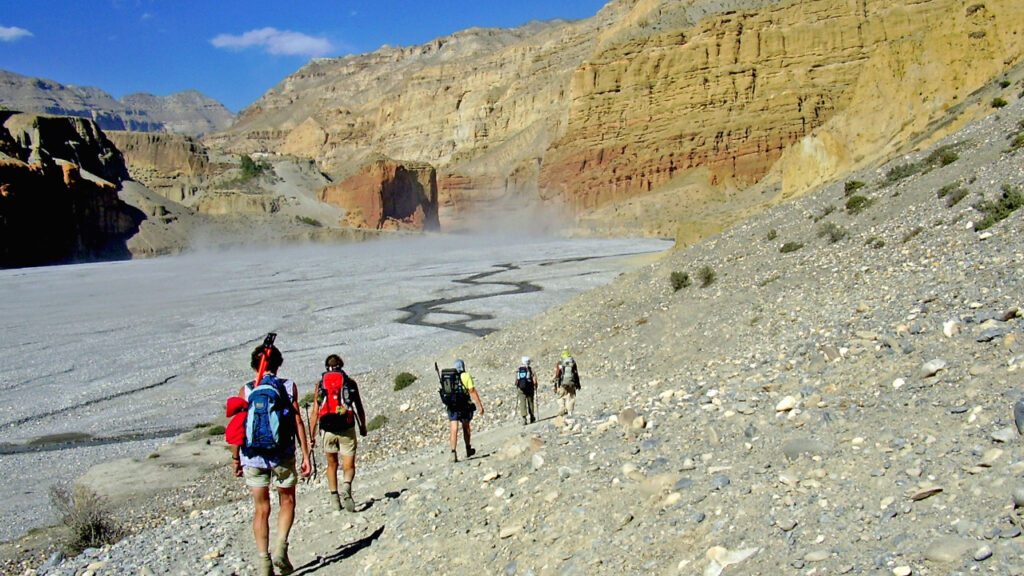 Trekker walking through arid mountain trail